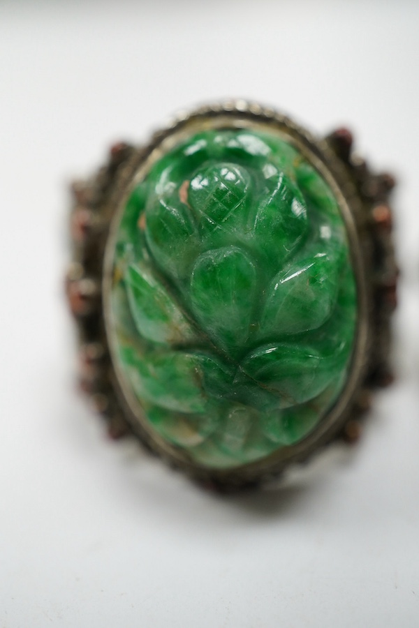 Two Chinese or Burmese jadeite or jade mounted white metal rings. Condition - fair